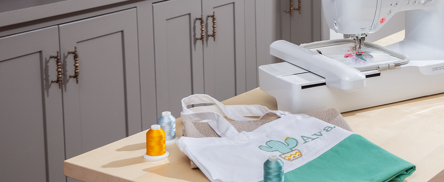 Sewing/embroidery machine on craft table with monogrammed tote bag with embroidered cactus design