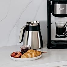 Thermal carafe with croissants jam and berries