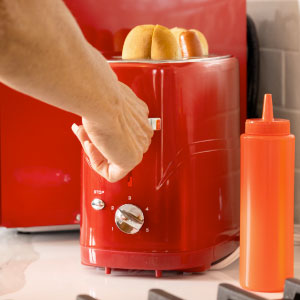 Red retro toaster for hot dogs and buns with hand pushing lever down with red ketchup bottle.