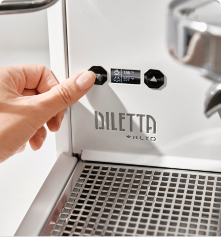 Hand adjusting settings on Diletta espresso machine with digital display.